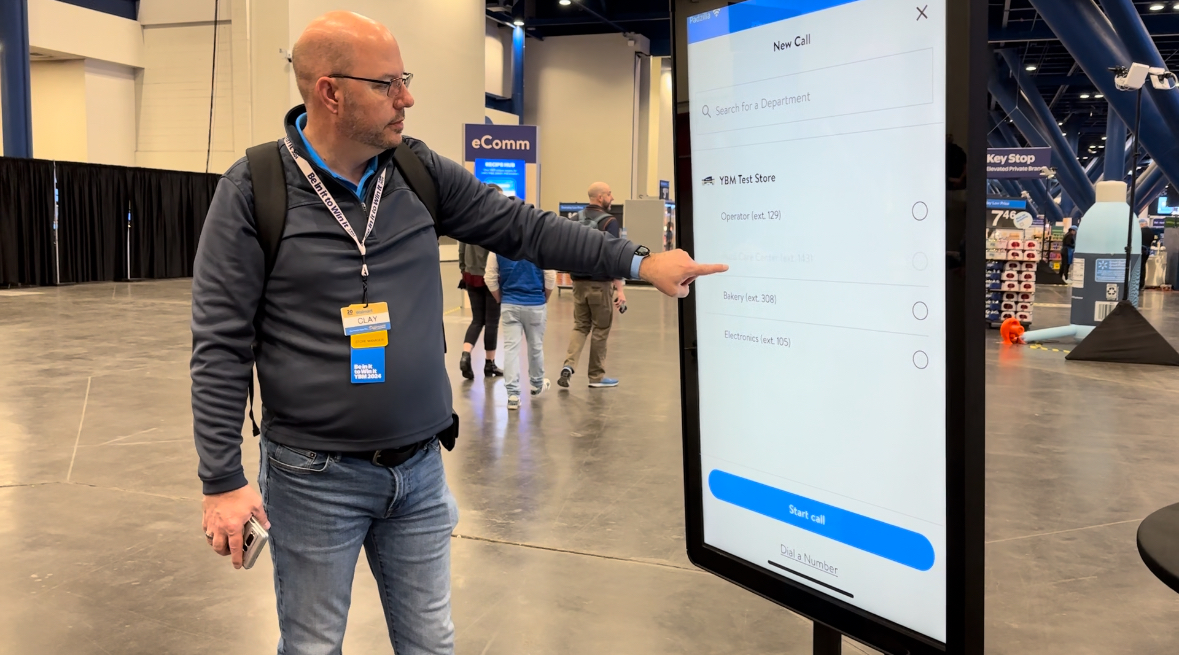 man uses touchscreen kiosk at trade show