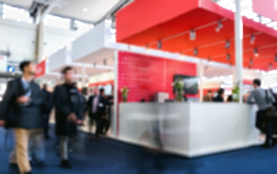 business people walking in trade show booth intentionally blurred